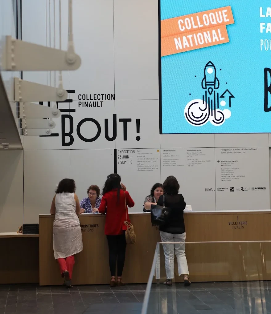 Trois personnes à l'accueil du Colloque au couvent des Jacobins