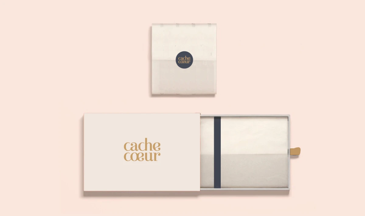 Coffret haut de gamme Cache Cœur avec logo doré et design minimaliste, illustrant la nouvelle identité visuelle élégante et responsable de la marque française de lingerie de maternité.