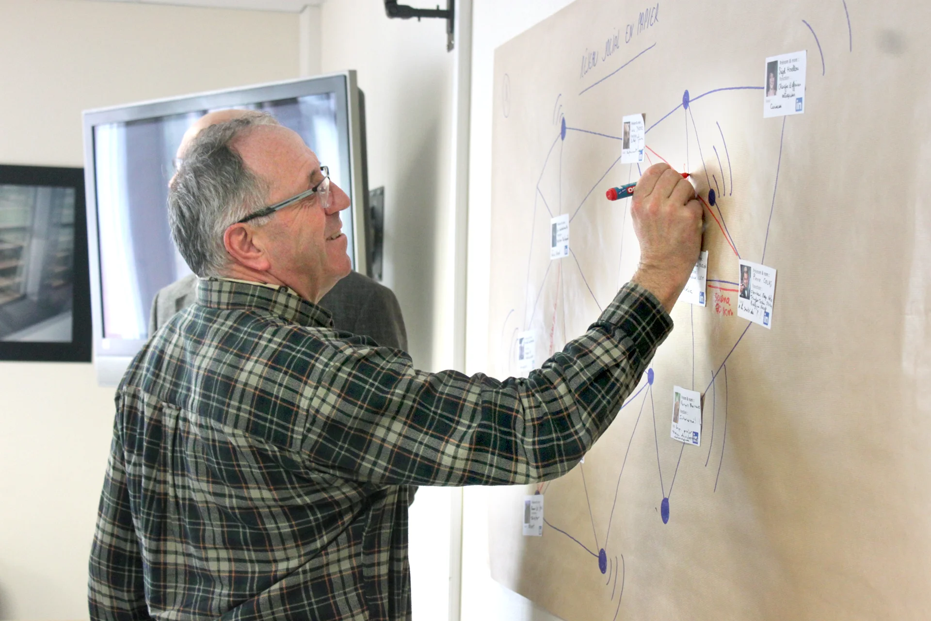 Participant en train de dessiner des liens entre les acteurs du réseau sur une fresque collaborative dans le cadre de la co-construction du Campus mondial de la mer – animé par Hippocampe