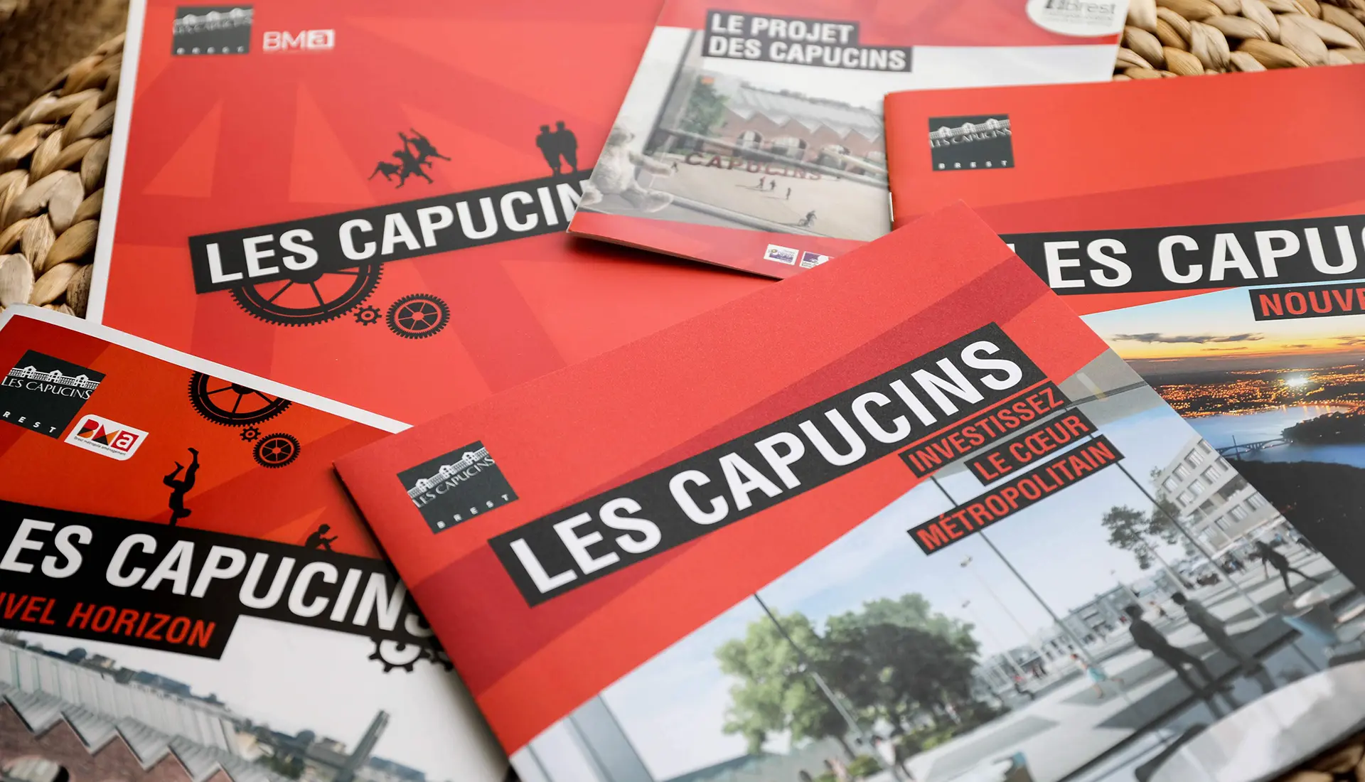 Ensemble de brochures rouges illustrant le projet de reconversion urbaine des Capucins à Brest, conçues par Hippocampe