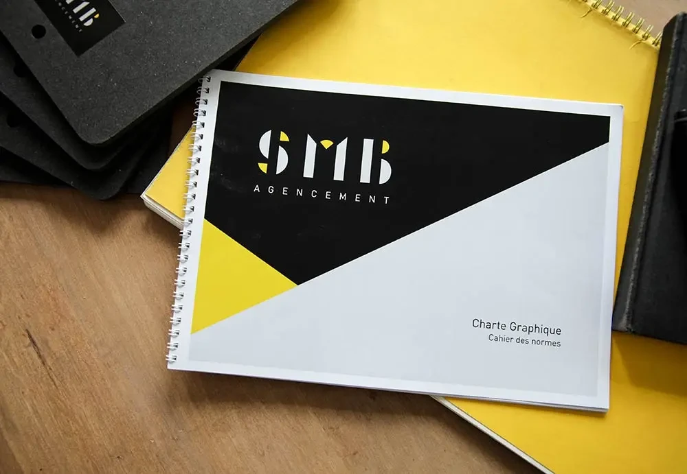 Charte graphique SMB Agencement en couverture spirale avec logo, couleurs et principes de composition