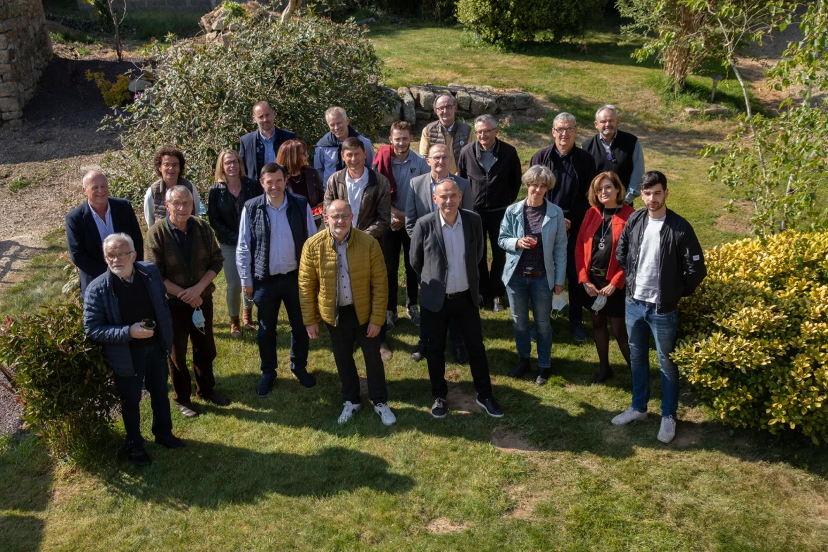 Groupe de femmes et d’hommes debout dans un jardin, réunis pour une rencontre organisée par le think tank Le K à Plouédern.