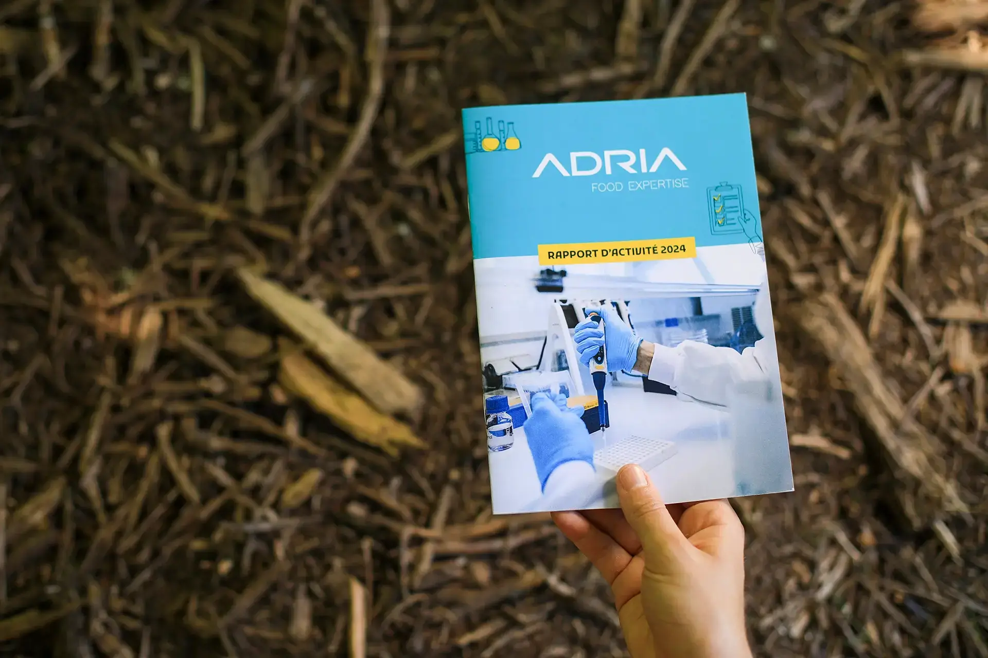 Couverture du rapport d’activité 2024 d’ADRIA illustrant la nouvelle identité visuelle conçue par l’agence Hippocampe, symbolisant la modernisation et la cohérence de la communication de l’institut agroalimentaire